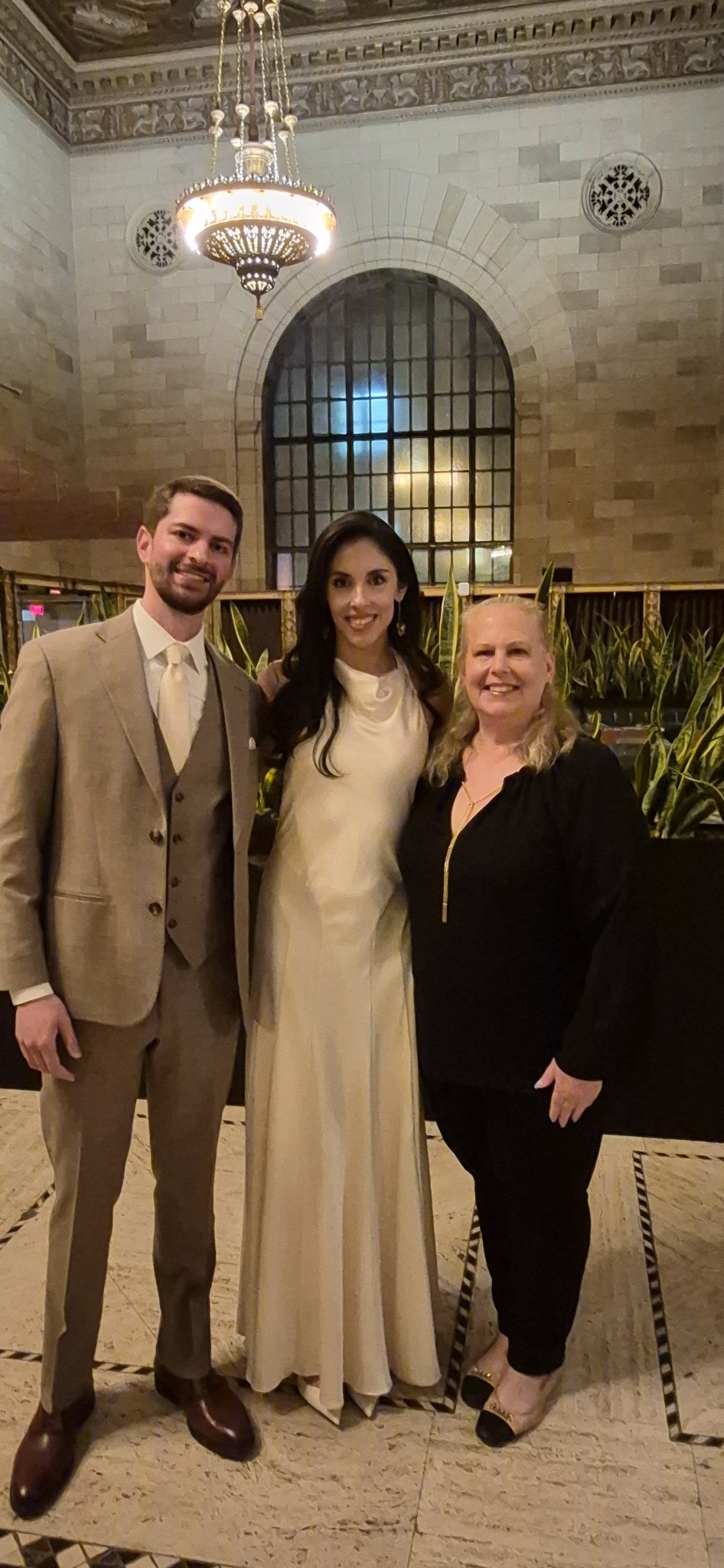 Natasha avec un couple dans un lieu de cérémonie élégant